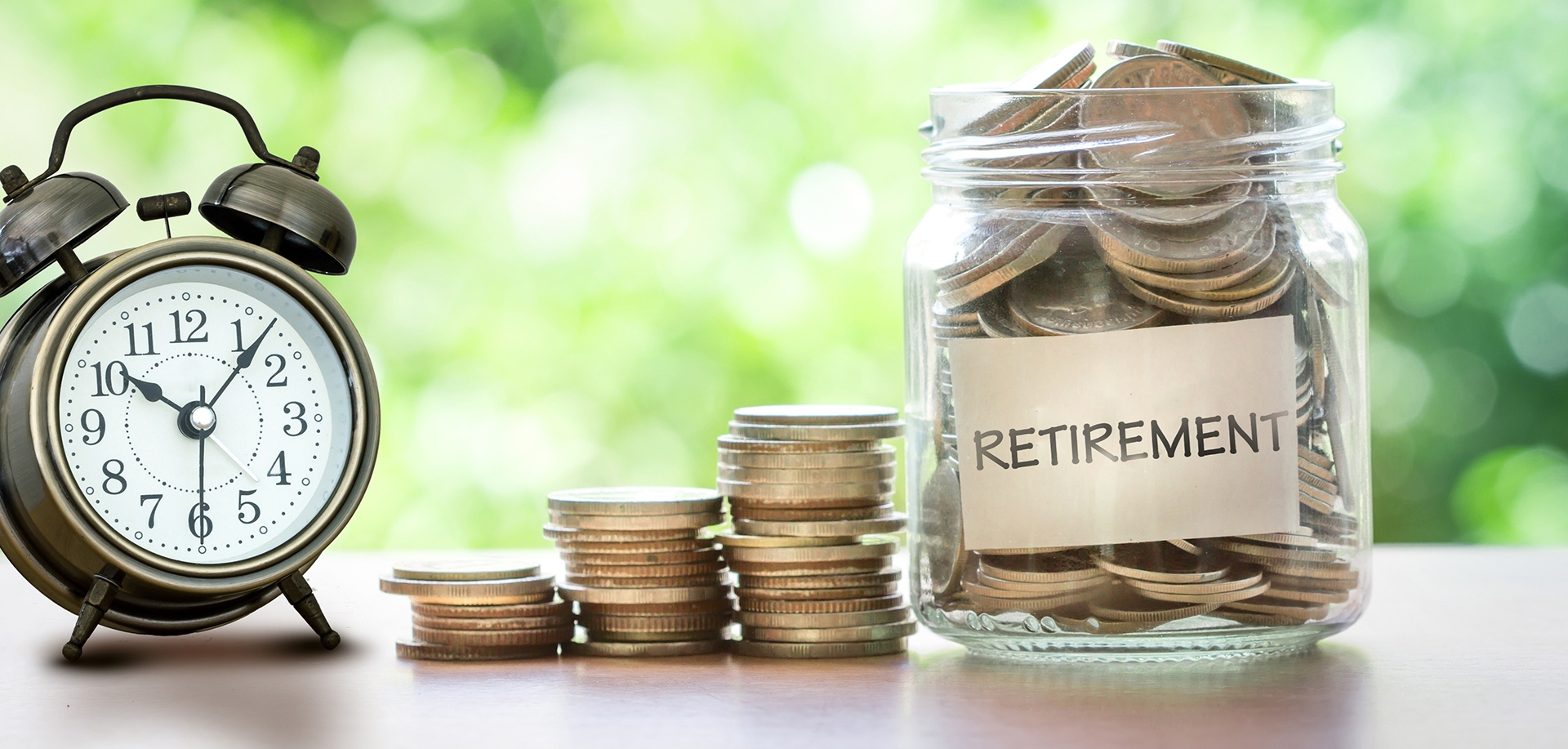 person putting coins into a jar that is marked Retirement